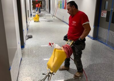 Marble Lite Inc. technician performing commercial marble floor polishing in an NYC office hallway.
